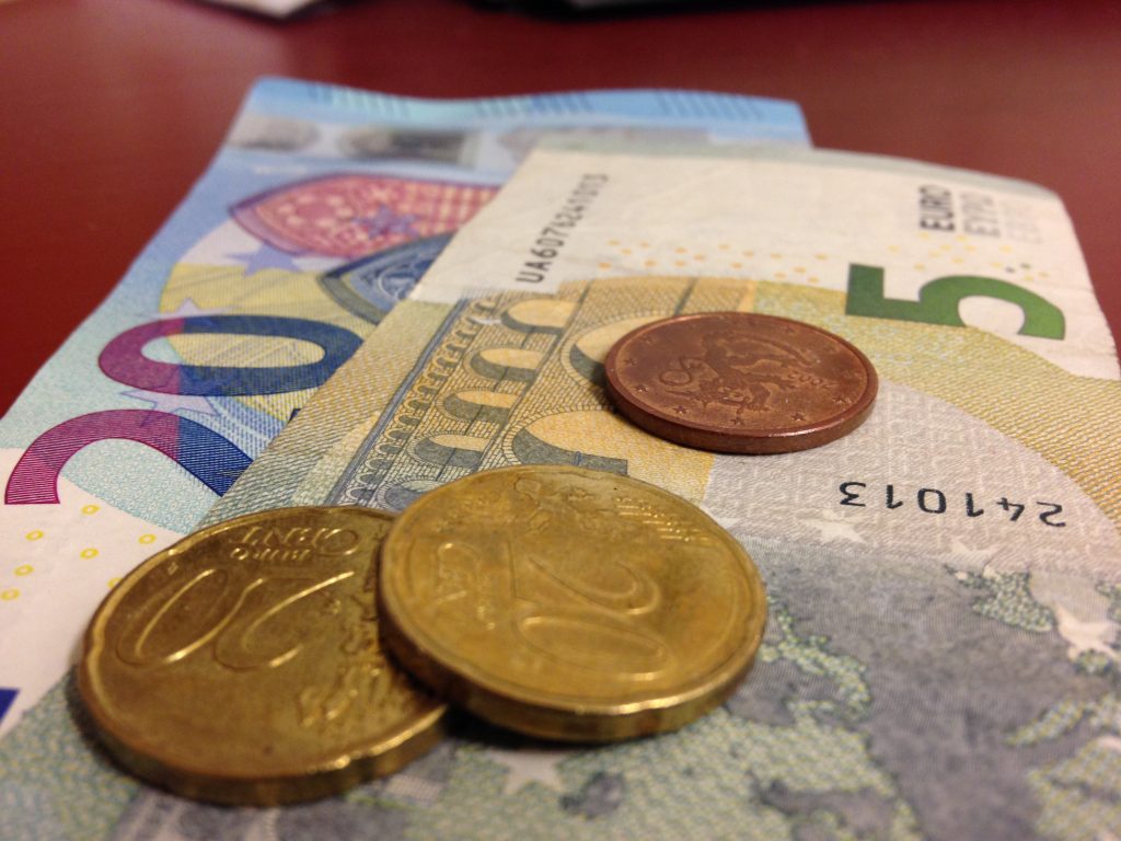 Kuvassa 20 ja 5 euron setelit ja kolme kolikkoa niiden päällä.